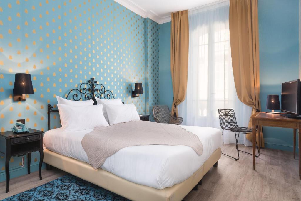 尼斯快乐文化格里马尔迪酒店 的一间卧室设有一张床和蓝色的墙壁