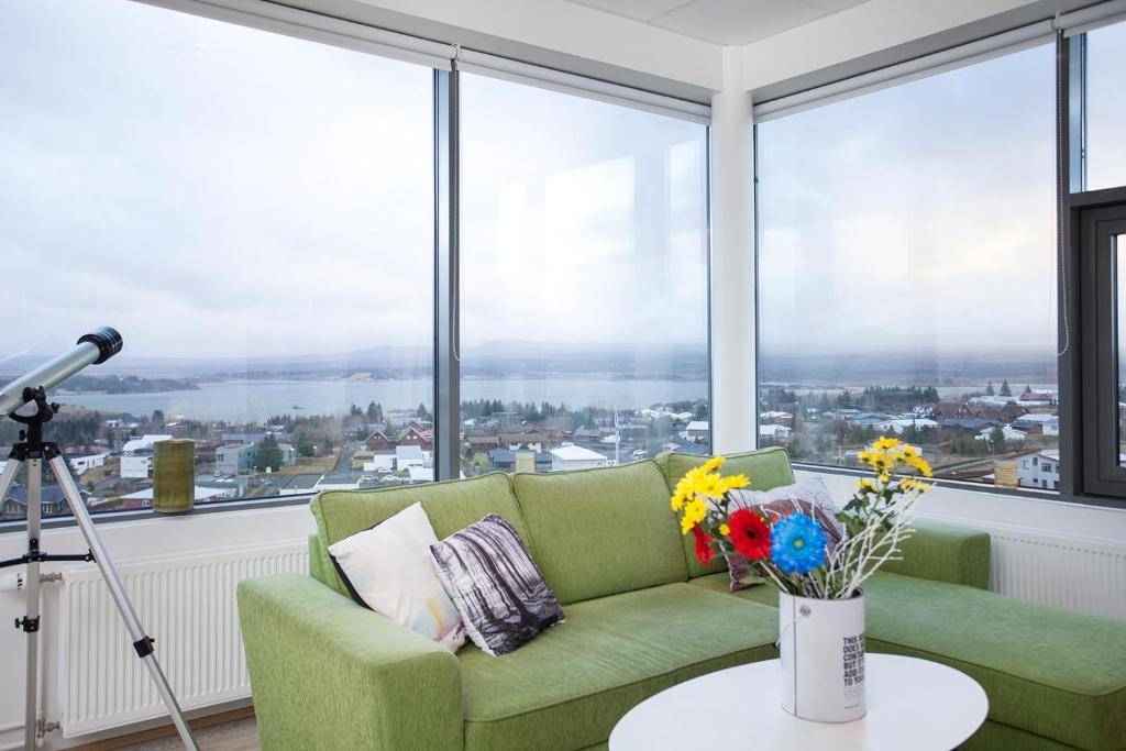 雷克雅未克Blue Mountain Apartments by Heimaleiga的客厅设有绿色沙发和大窗户