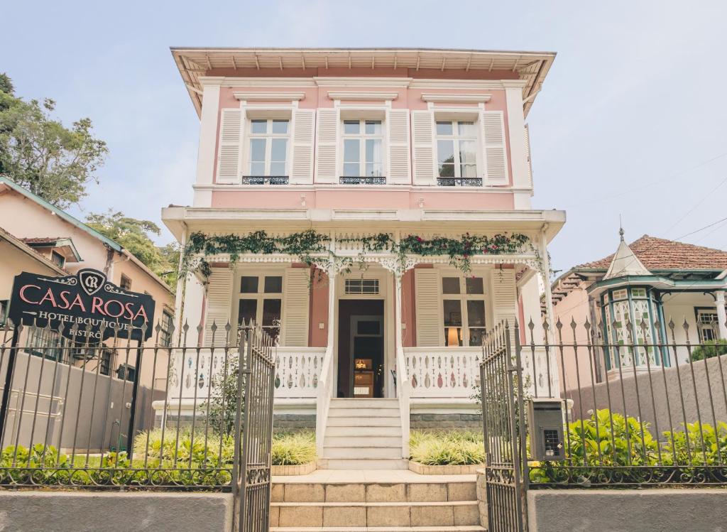 彼得罗波利斯Casa Rosa Hotel Boutique的粉红色的房子,前面有一个门