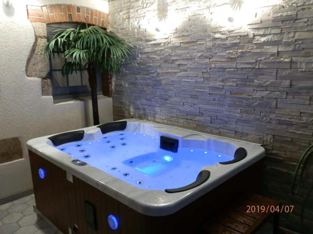 MauléonGITE IZALIN AVEC SPA A 20 min du Puy du Fou的一个带砖墙的客房内的按摩浴缸