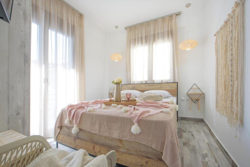 依诺罗达Meltemi luxury apartments的一间卧室配有一张带粉色毯子的木床