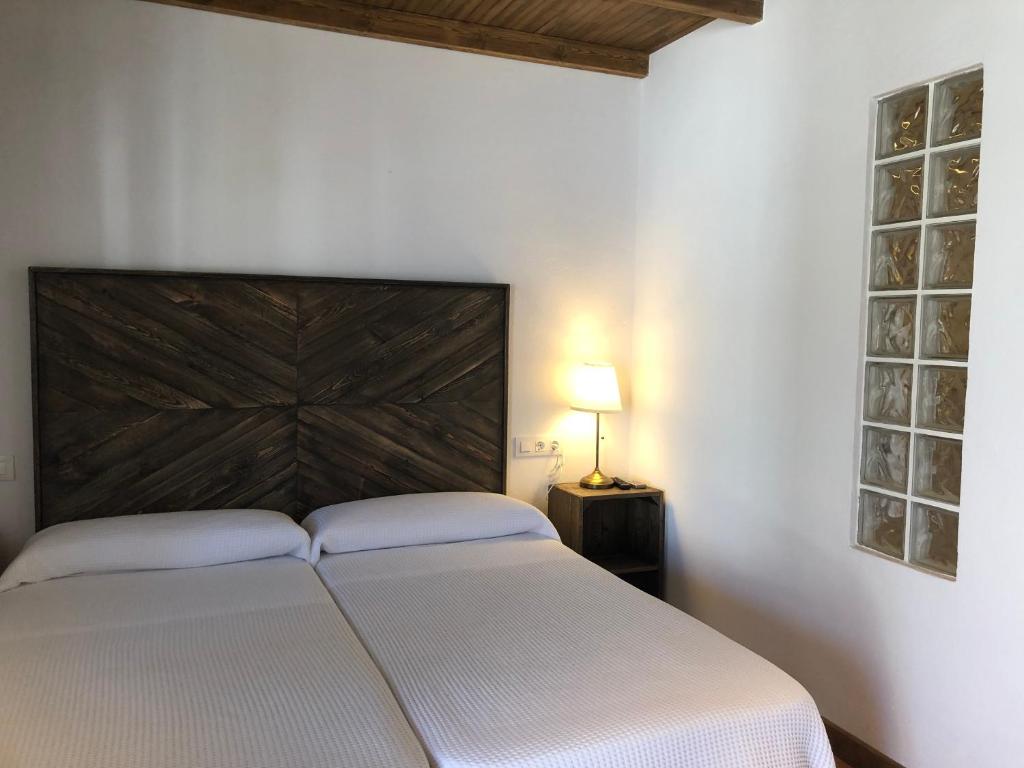 麦地那西多尼亚Alojamiento Rural El Soldao的卧室配有白色的床和木制床头板