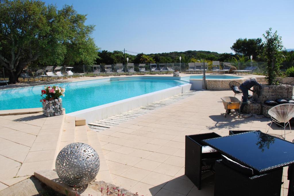 皮亚诺托利-卡尔达雷洛瑞贝利努公寓酒店的庭院设有游泳池、桌子和椅子。