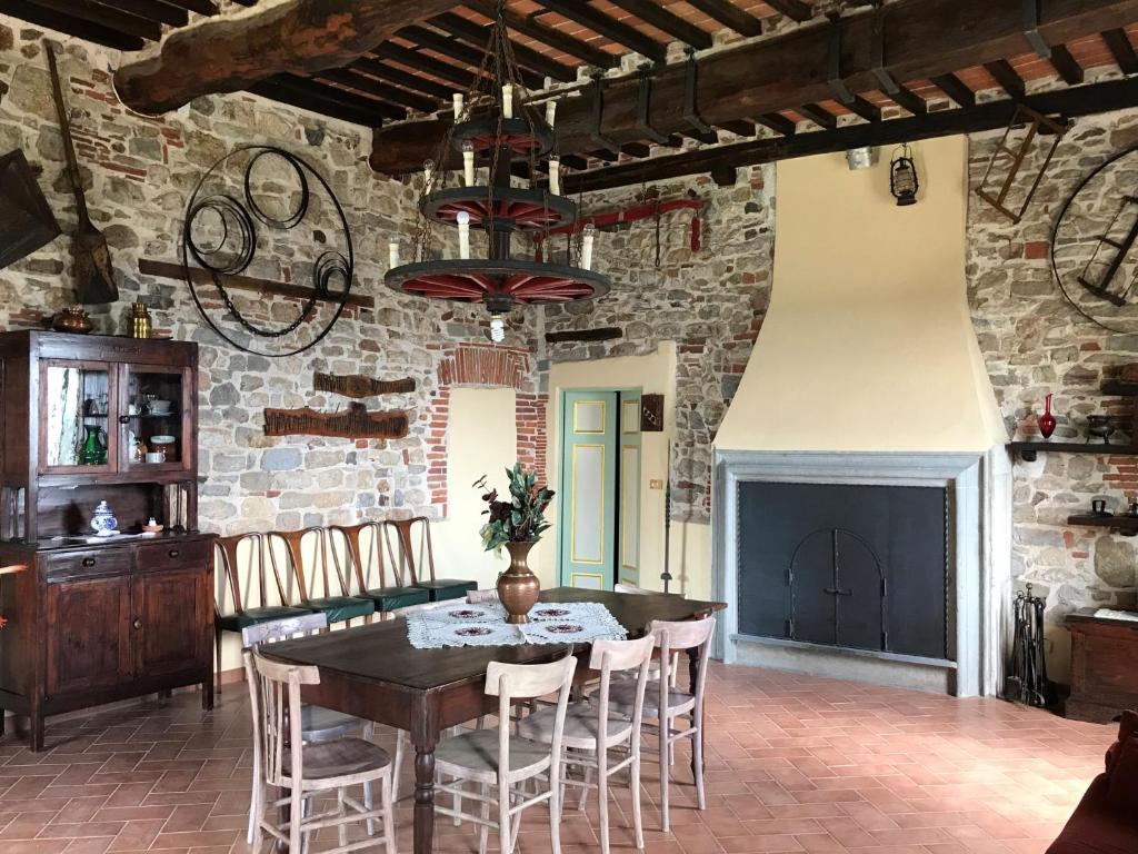 卡麦奥雷La Calona的一间设有桌椅和砖墙的用餐室