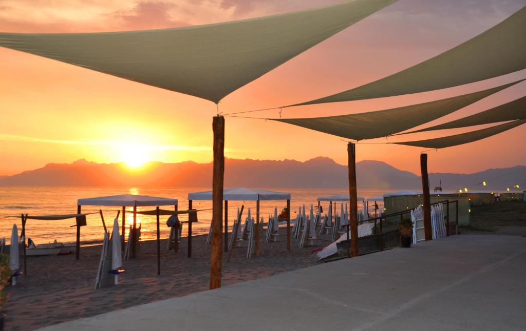 巴蒂帕利亚Albergo Riviera Spineta的日落时在海滩上放一把遮阳伞