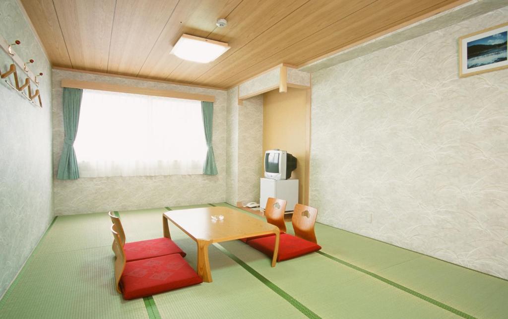 京都Hotel Station Kyoto West的客厅配有桌子和两把椅子