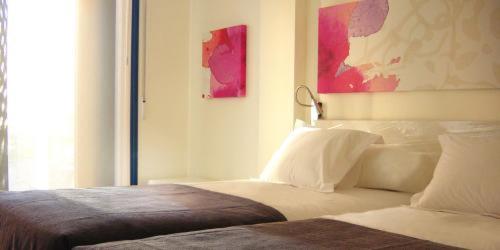 布尔戈斯艾库阿乐旅馆的卧室配有一张床,墙上挂有绘画作品