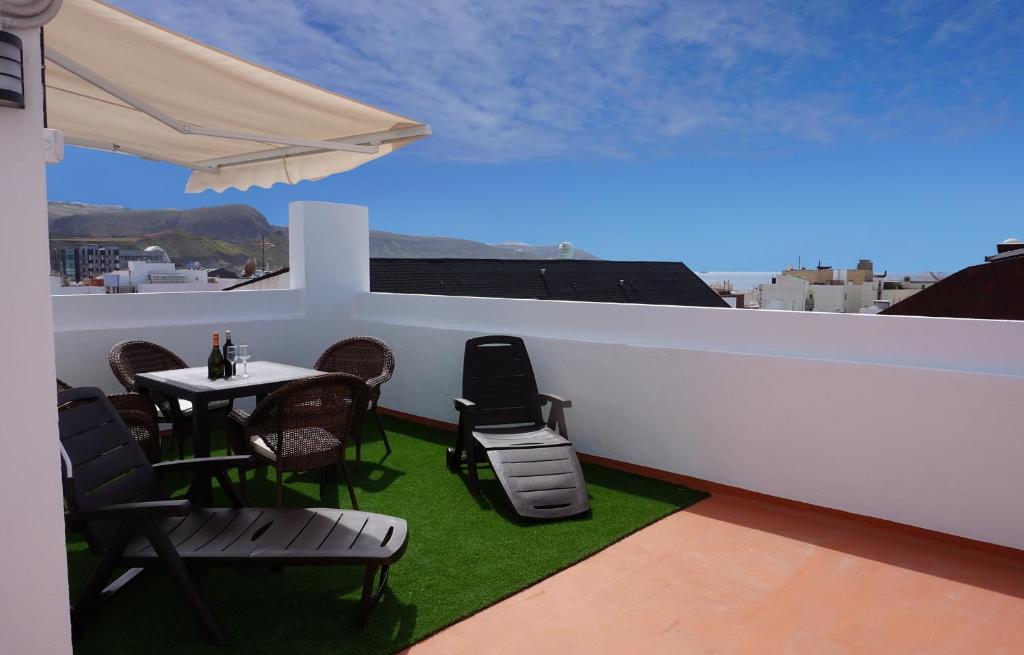 大加那利岛拉斯帕尔马斯Apartamento Conpe的屋顶阳台配有桌椅