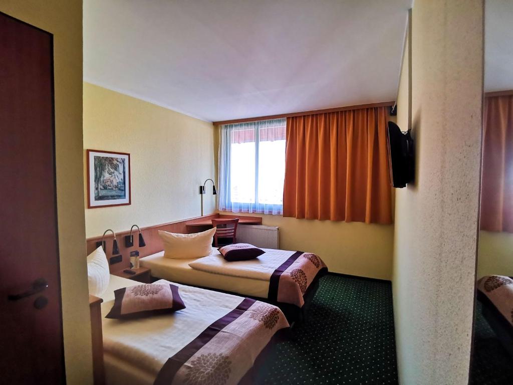 奎德林堡安格鲁 - 奎德林堡酒店的酒店客房设有两张床和窗户。