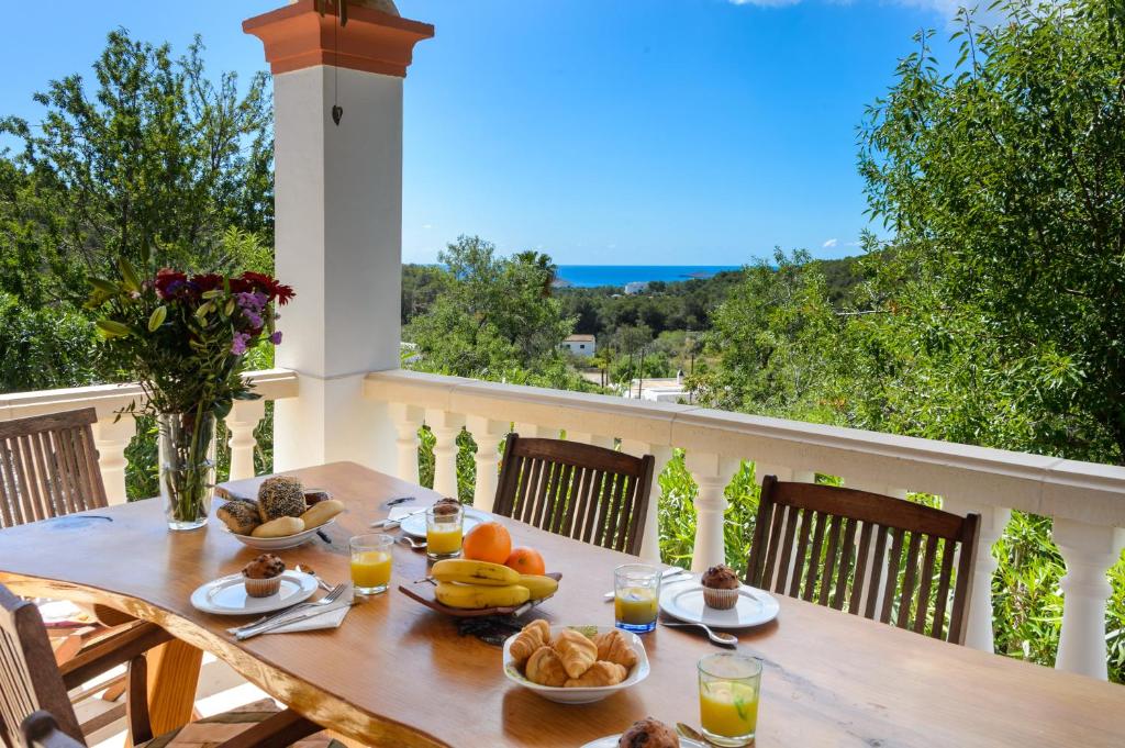圣卡洛斯Villa Can Ameler的阳台上的桌子上摆放着食物和水果