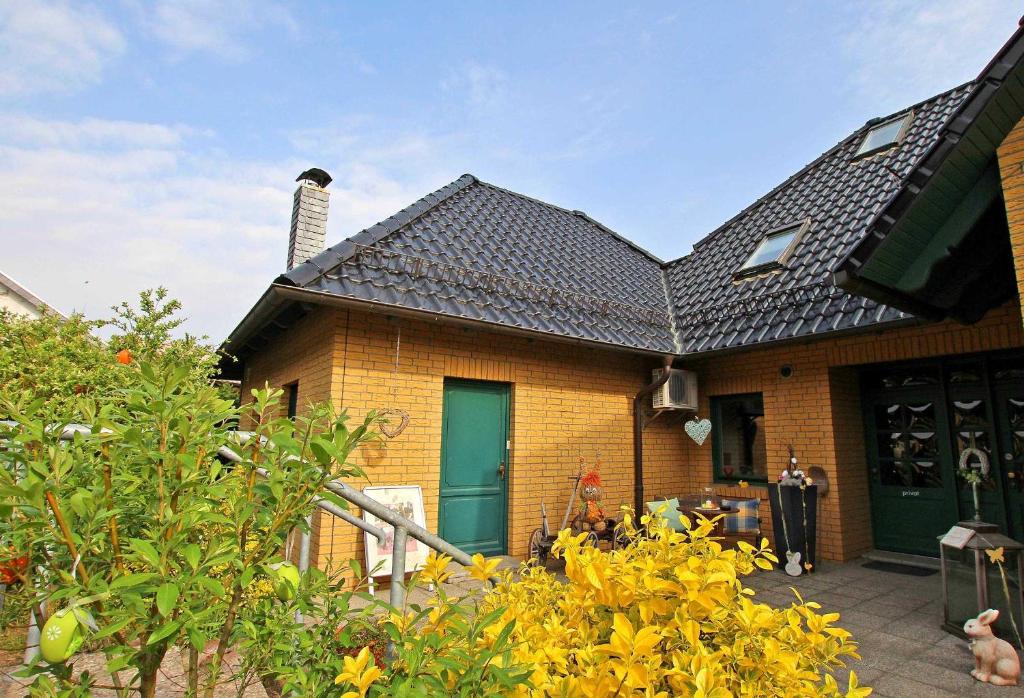 克林克Ferienwohnung Klink SEE 10001的砖房,有绿门和灌木丛