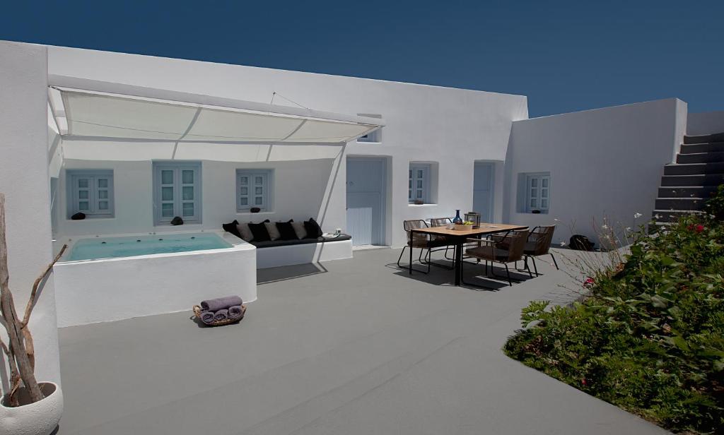 梅加洛克里阿尼莫里亚别墅酒店的一个带桌子和游泳池的白色庭院