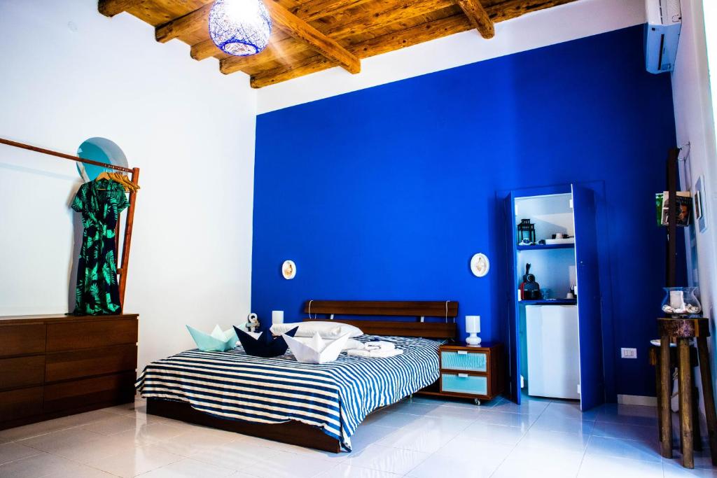 特拉尼Terra Del Sole的一间卧室设有蓝色的墙壁和一张床