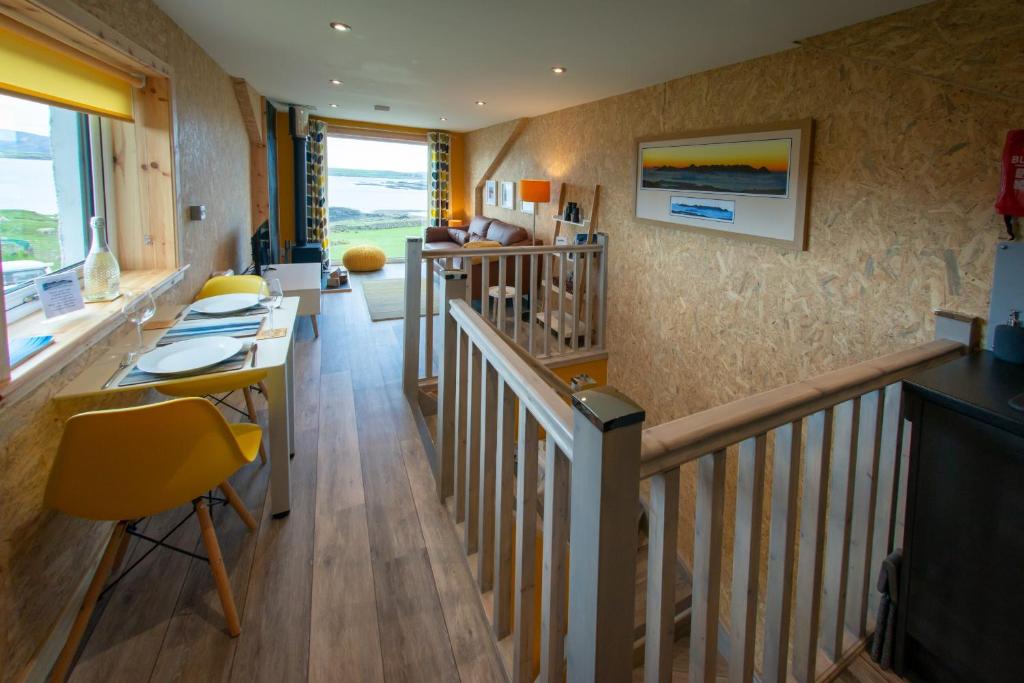 StruanLochanside的客房设有带桌子和黄色椅子的楼梯。