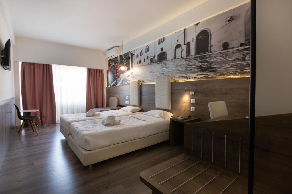 塞萨洛尼基大都市酒店的酒店客房,配有一张床铺和一张带照片的墙壁