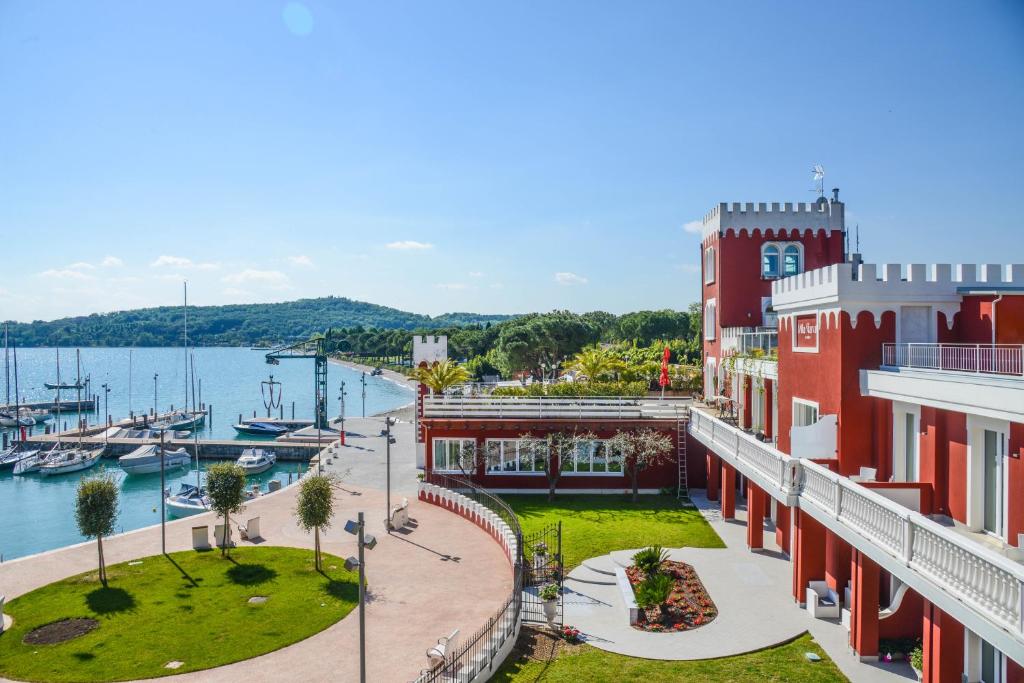 加达湖畔帕登赫Hotel Villa Garuti的享有码头和红色建筑的景色
