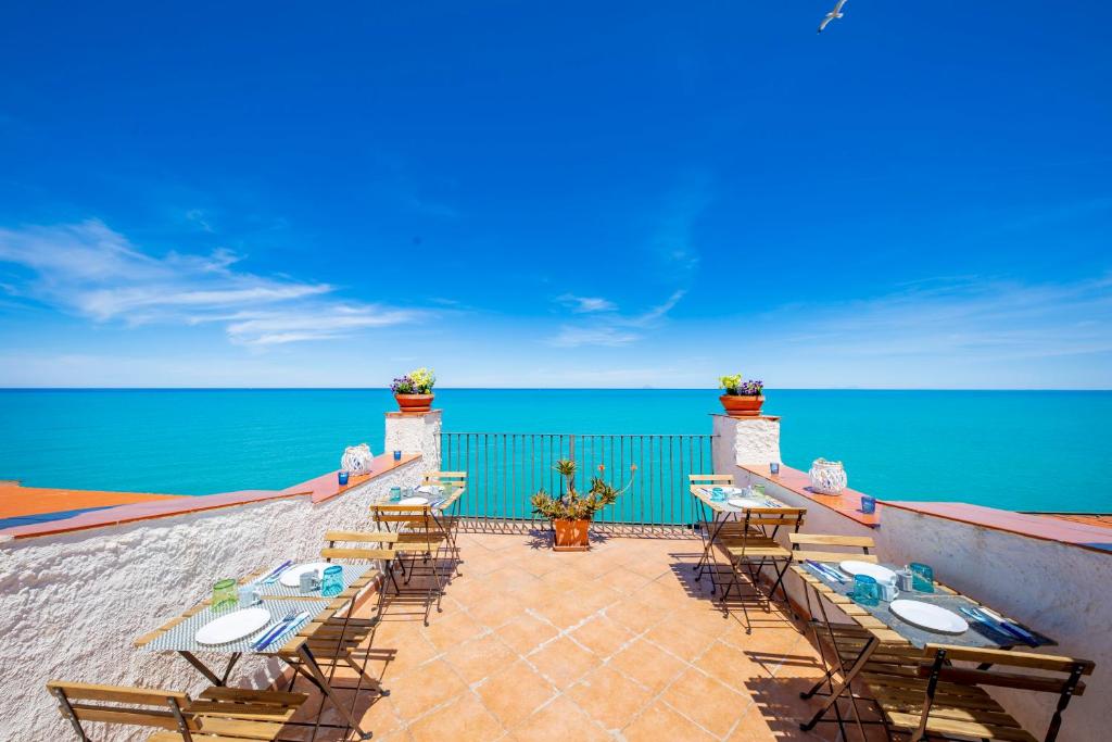 切法卢卡萨诺瓦旅馆的一个带桌椅的庭院,俯瞰着大海