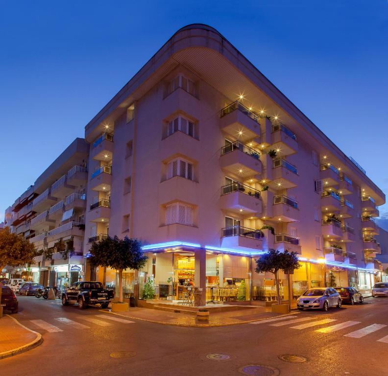 圣埃乌拉利亚杜克沙普拉亚公寓式酒店的夜行的街道上一座白色的大建筑