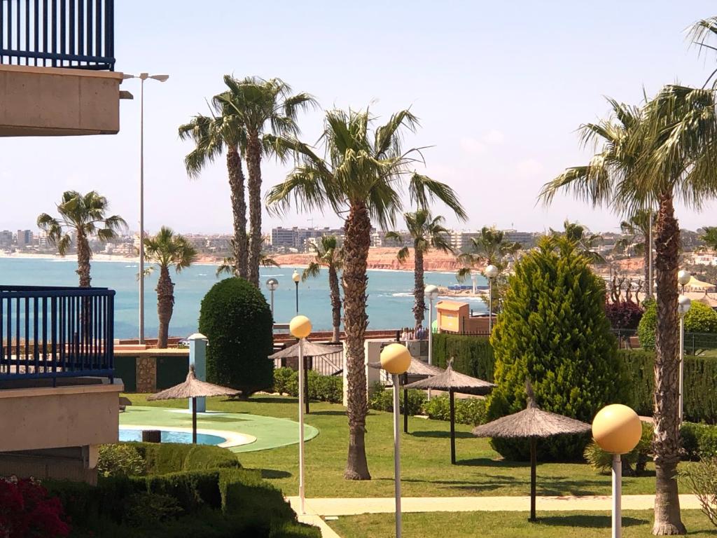 卡布罗伊格Cabo Roig - Blue Luxury Apartment的享有棕榈树和遮阳伞的度假村景色