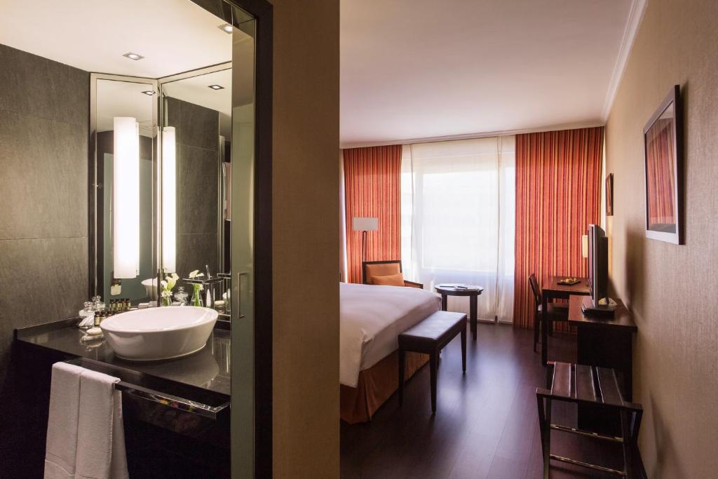 马德里铂尔曼马德里机场展会酒店的酒店客房设有床、水槽和镜子