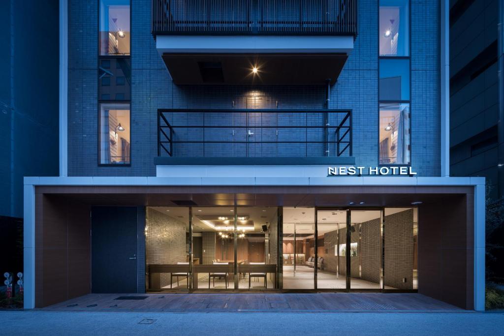 广岛Nest Hotel Hiroshima Hatchobori的一座晚上进入酒店的第一个大楼