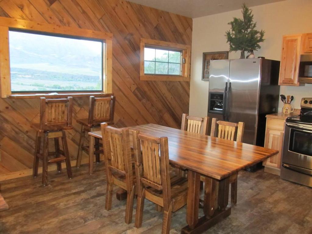 麋鹿城Mountain Man Cabin的厨房配有木桌和冰箱。