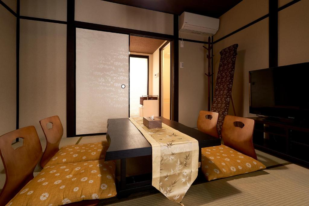 京都憩 出町柳２(ikoi DemachiyanagiⅡ)的配有桌椅和电视的客房