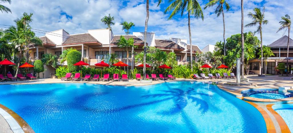 芭东海滩Coconut Village Resort Phuket - SHA Extra Plus的一个带椅子和遮阳伞的度假游泳池