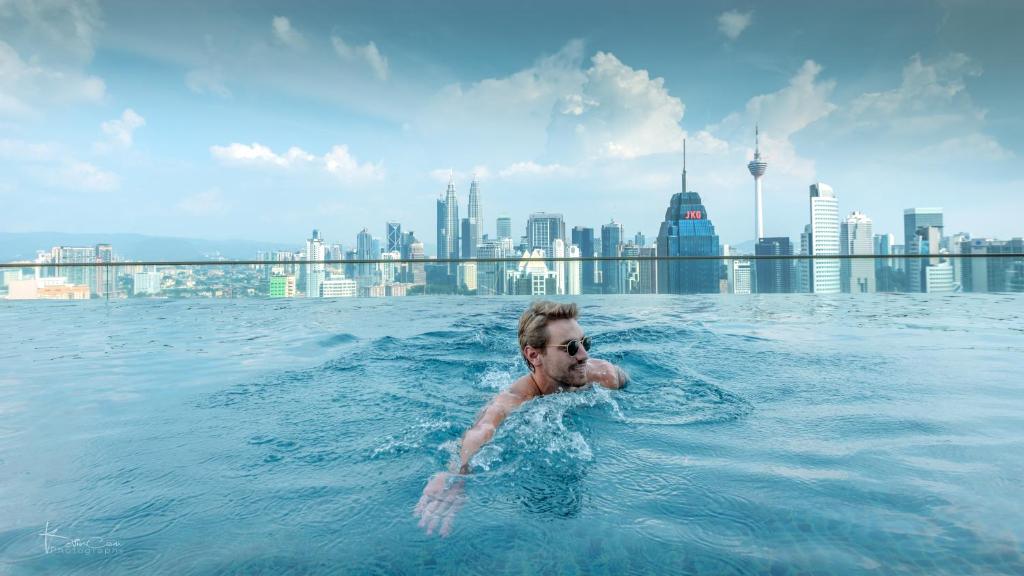 吉隆坡Penthouse on 34 - The Highest Unit and Best Views in Regalia & Private Rooftop Terrace的建筑物游泳池里的水中人