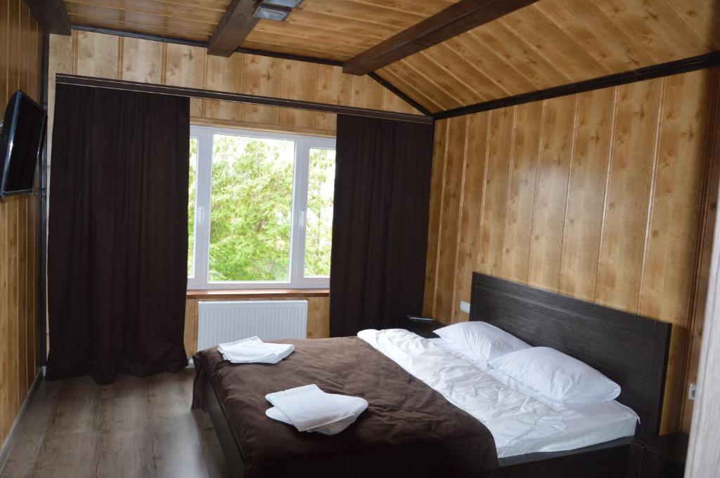 卡缅涅茨-波多利斯基Royal House的一间卧室配有一张床,上面有两条毛巾