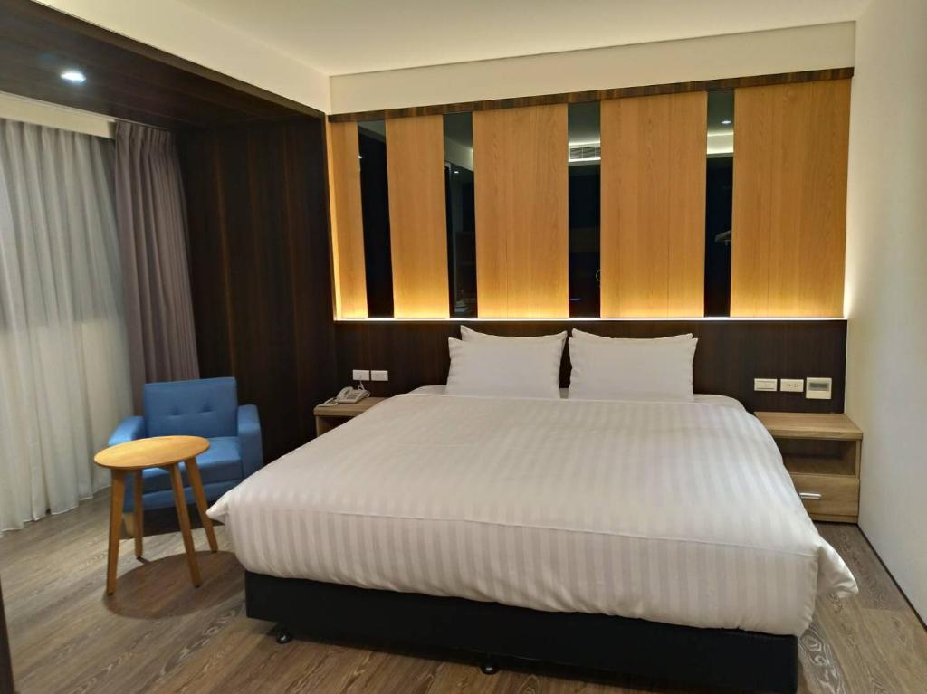 嘉义市兰潭泛月文旅的一间卧室配有一张大床和一张蓝色椅子