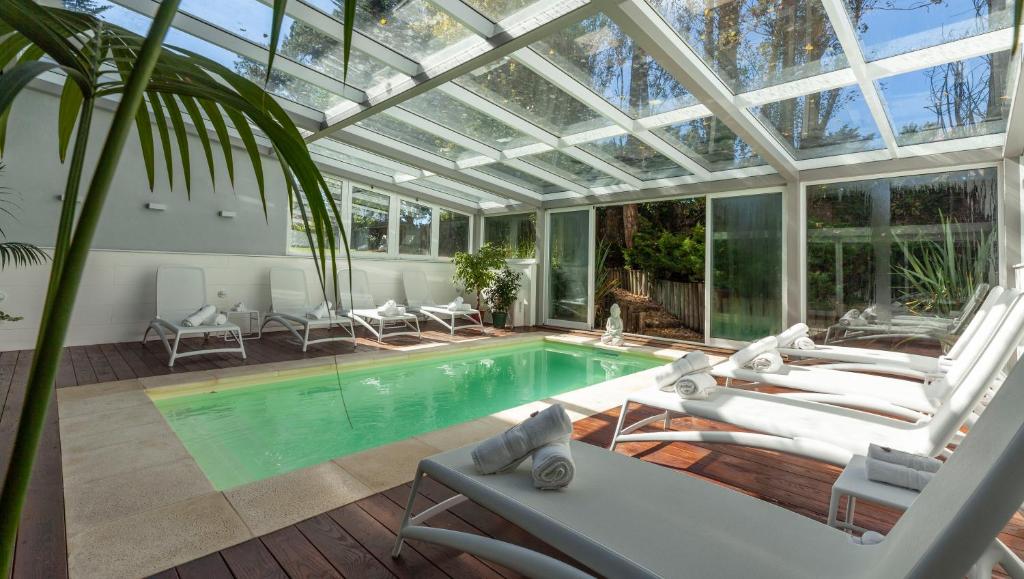 埃斯特角城AWA精品设计酒店的温室设有玻璃天花板和游泳池