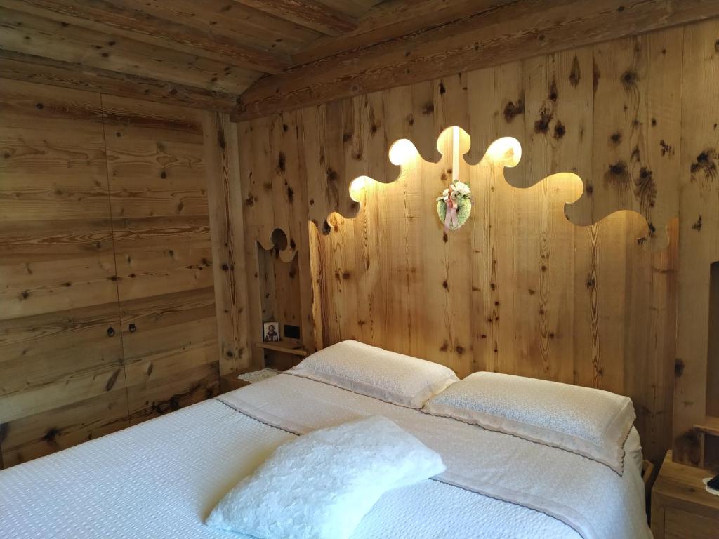 科尔蒂纳丹佩佐Daniela Apartment的卧室配有木墙内的一张床