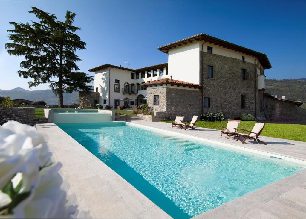 Villongo SantʼAlessandroPodere Castel Merlo Resort的别墅前设有游泳池