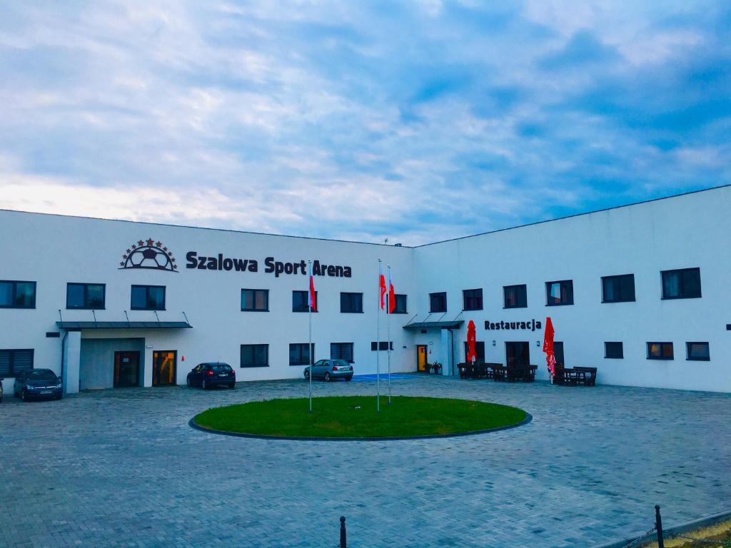 SzalowaSzalowa Sport Arena的一座白色的大建筑,前面有一个圆圈