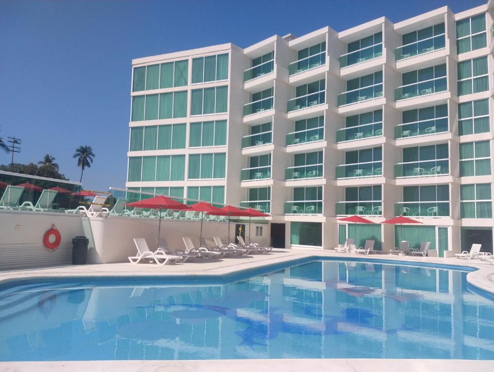 阿卡普尔科阿尔普尔科华美达酒店的一座带游泳池和椅子的酒店和一座建筑