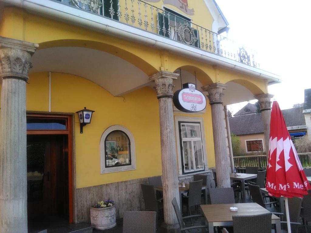 埃伦豪森Zur goldenen Krone的黄色的建筑,配有桌子和雨伞