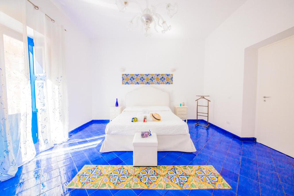 利帕里Punta Sallustro Lipari的一间卧室配有一张床,铺有蓝色的瓷砖地板。
