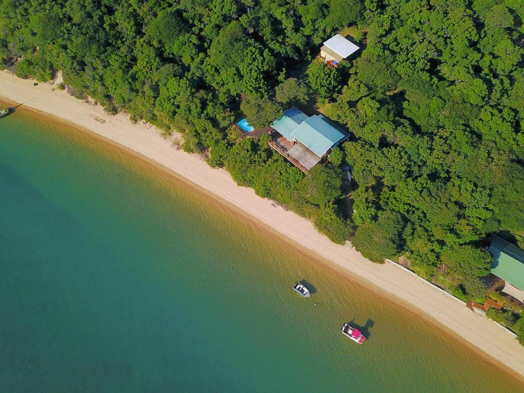 Santa MariaCasa Karibu at Santa Maria Machangulo Mozambique的享有海滩和水域的空中景致,设有房屋