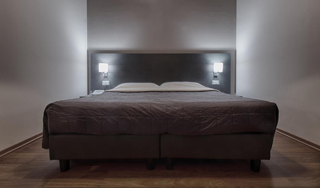 蒙卡列里十二酒店的一间卧室配有一张带黑色床头板的床
