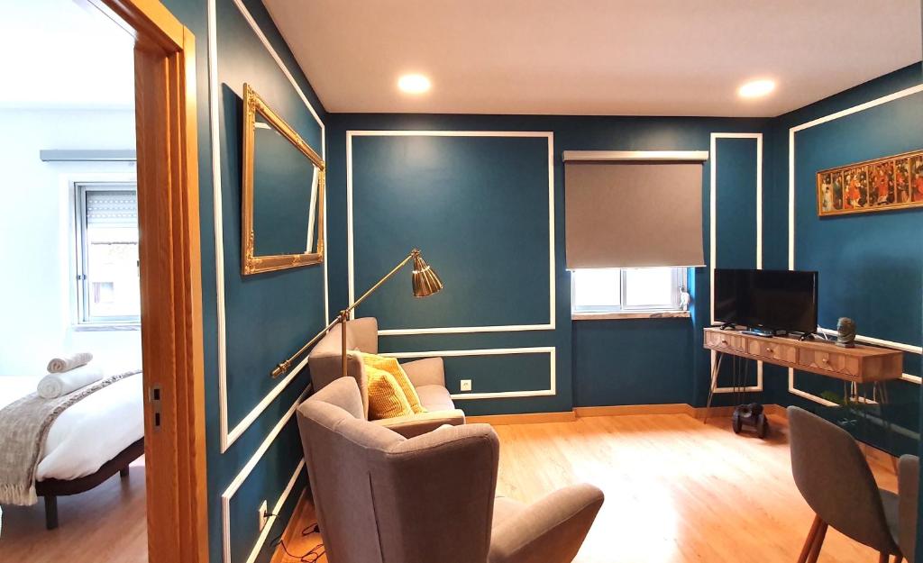 阿尔马达Afonso Galo Guest Apartments I的客房拥有蓝色的墙壁,配有椅子和书桌