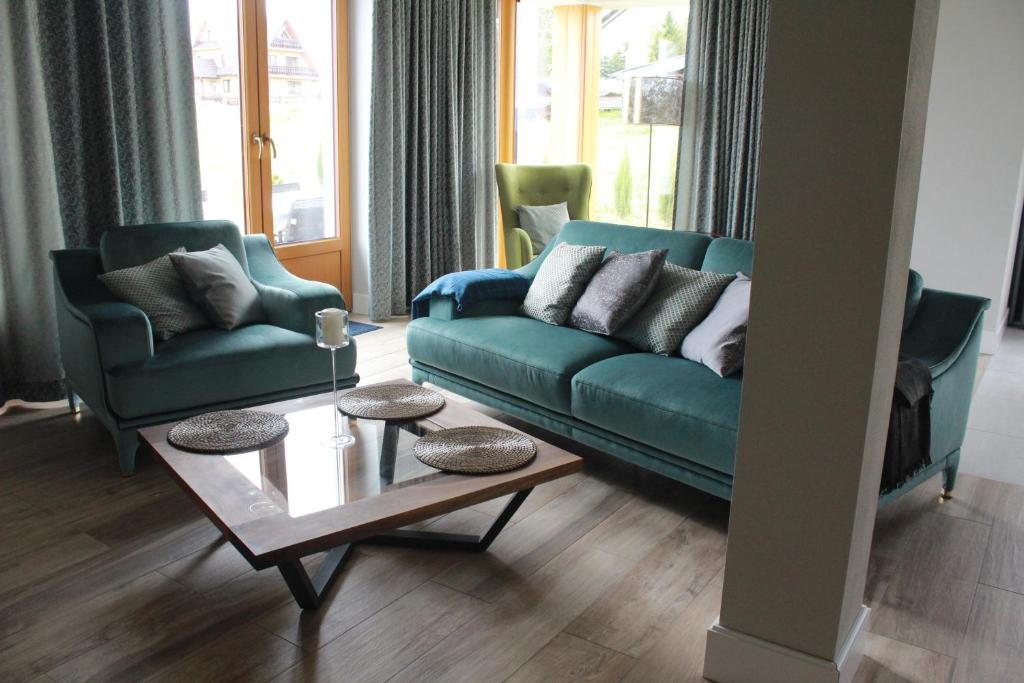GronkówMonsieur Henri的客厅配有绿色沙发和两把椅子