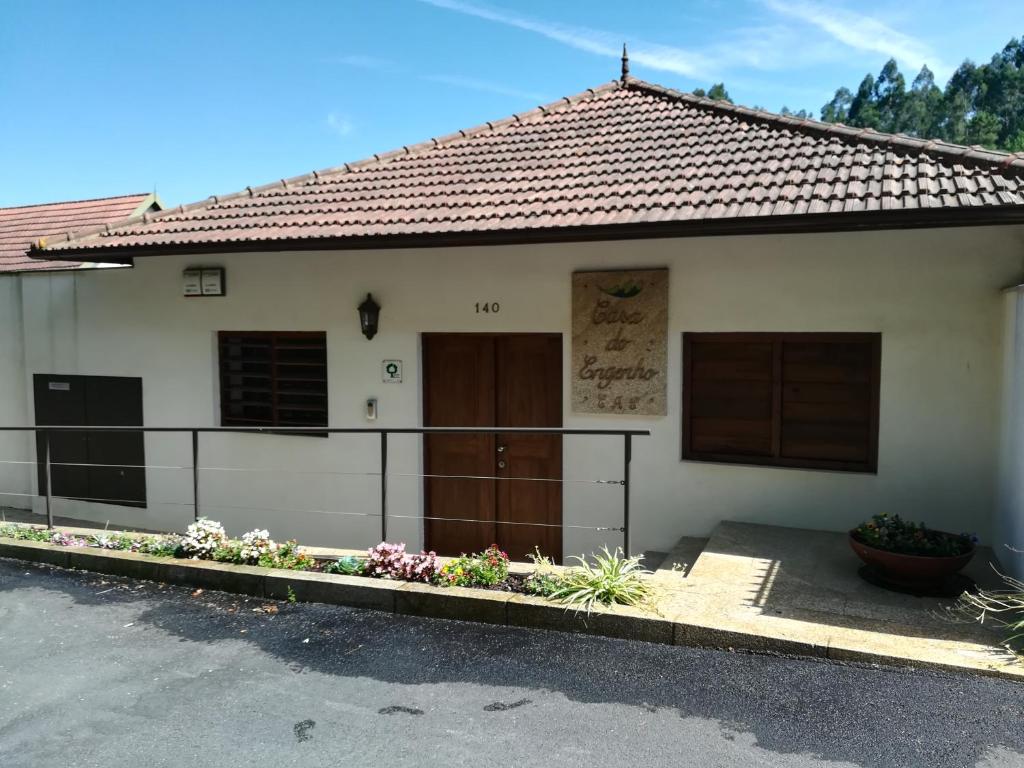 Caldas de São JorgeCasa do Engenho的门前有门和鲜花的白色房子