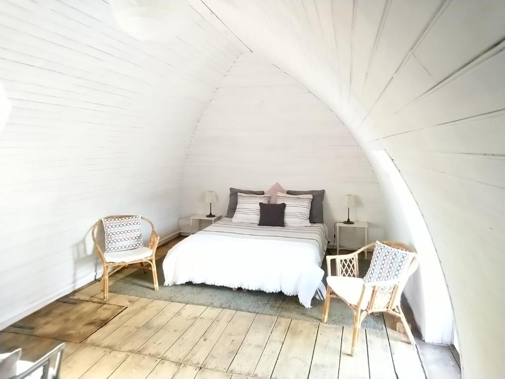 芒德La Soubeyranne的一间白色卧室,配有一张床和两把椅子