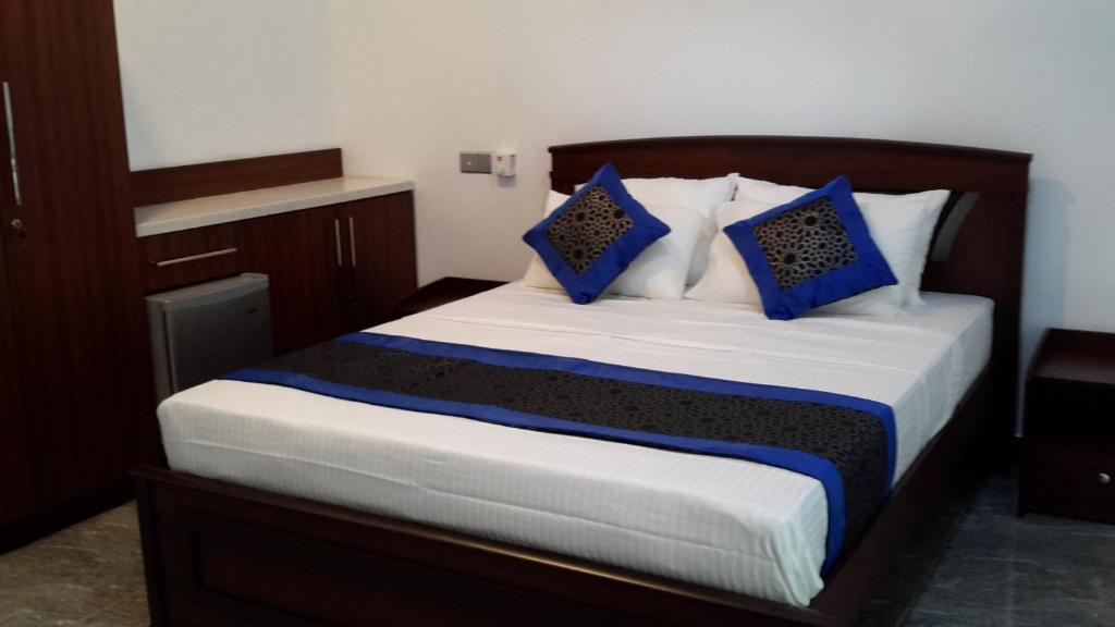 科伦坡Dumi's Shelter Home Stay的一间卧室配有一张带蓝色枕头的大床