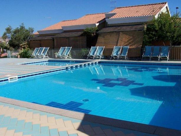阿尔巴塔克斯Appartamento presso Residence Verdemare的一座带椅子的大型游泳池和一座建筑