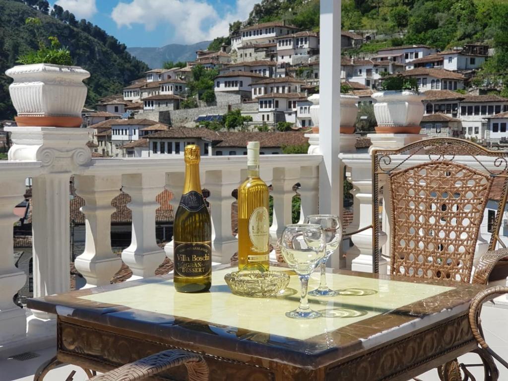 培拉特阿尔本埃勒兹旅馆的阳台上配有带葡萄酒瓶和玻璃杯的桌子