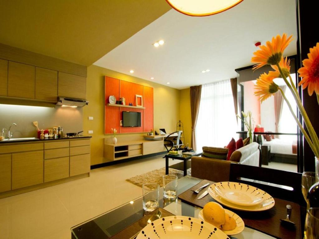 清迈韦帕蓝大型住宅的厨房以及带橙色橱柜和桌子的客厅。