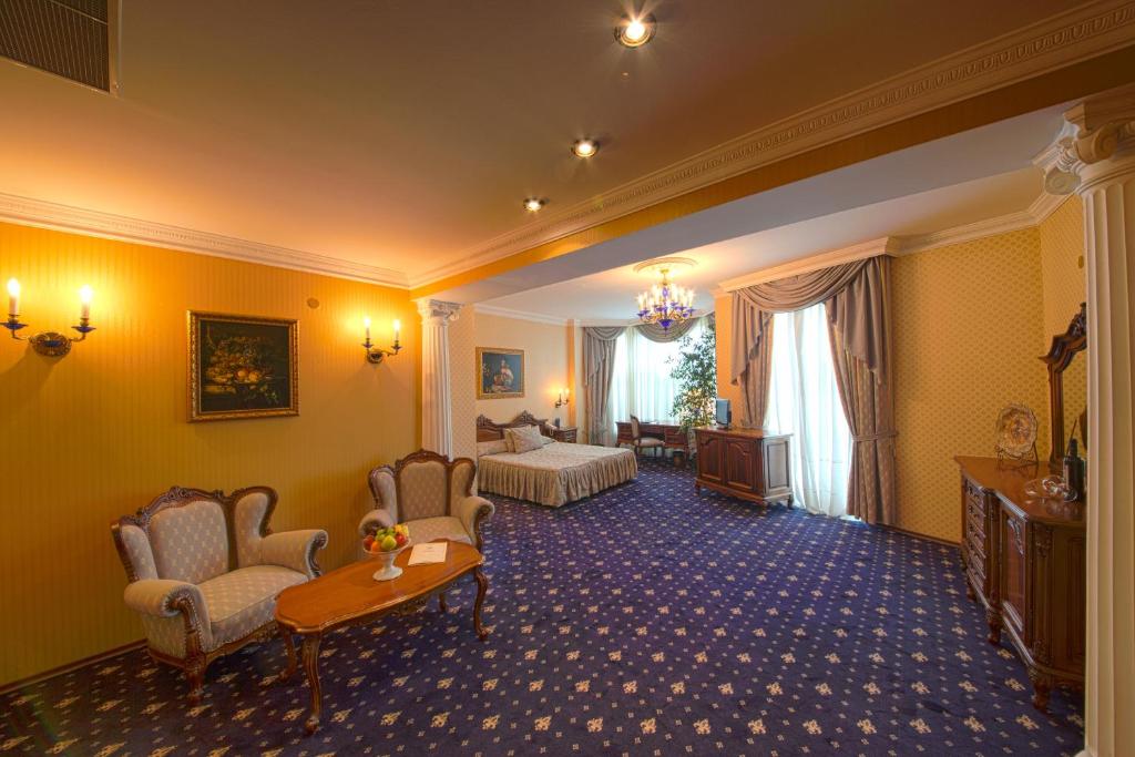 瓦尔纳伦敦格兰酒店的酒店客房带一张床、一张桌子和椅子