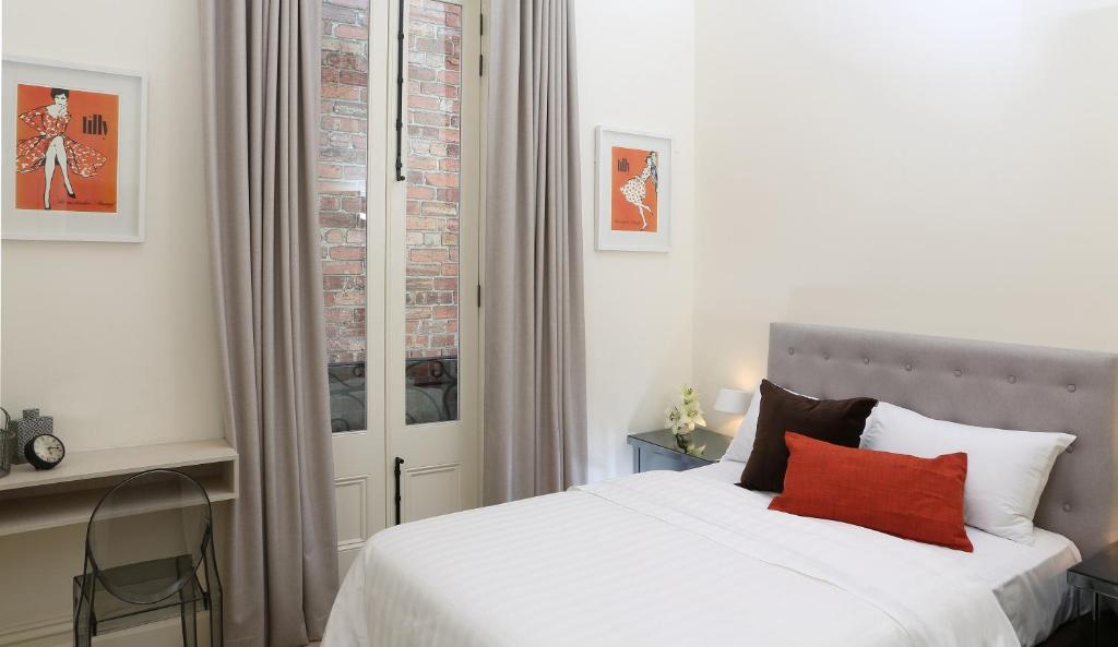 墨尔本Studio 4 - Saint George Accommodation的卧室配有白色的床和红色枕头